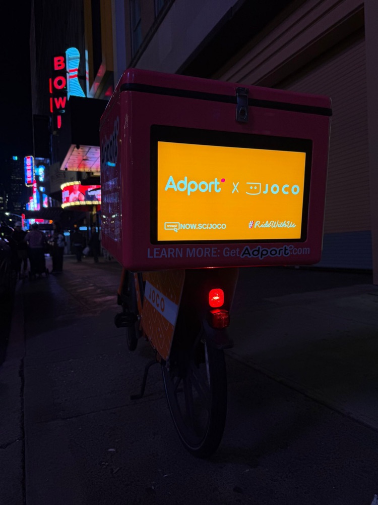 AI Screen on a JOCO delivery bike at night in Midtown